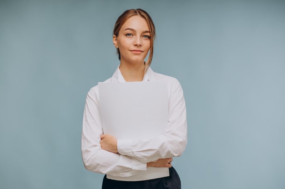 a woman wearing a white shirt and holding papers while standing isolated on a blue background